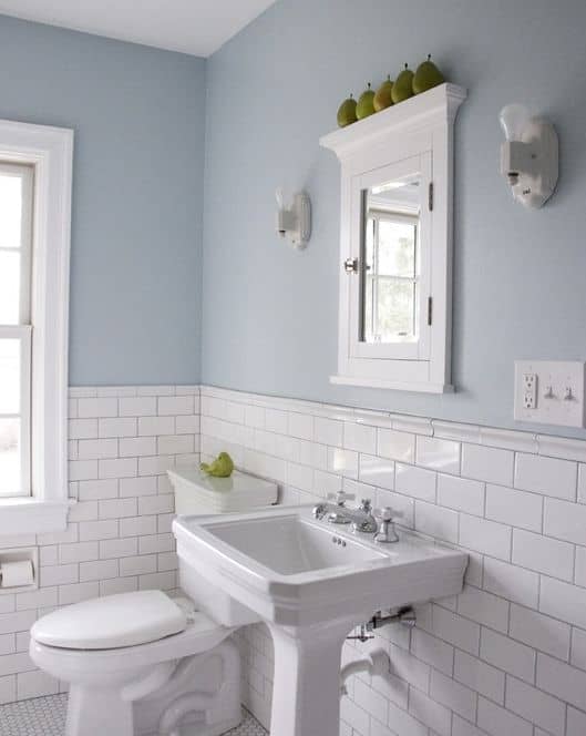 a traditionally styled bathroom space with subway tiles up half of the wall making the space appear bigger