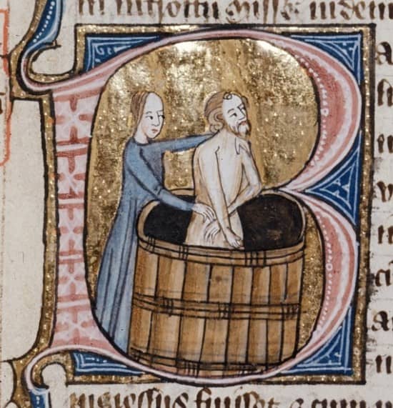 medieval illustration of a man bathing in a wooden bath