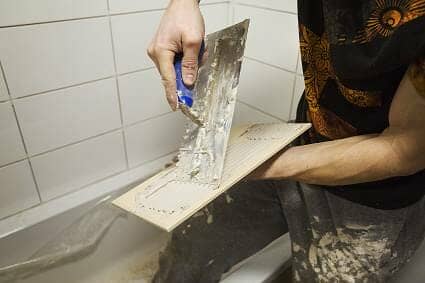A man tiling a new bathroom A man tiling a new bathroom