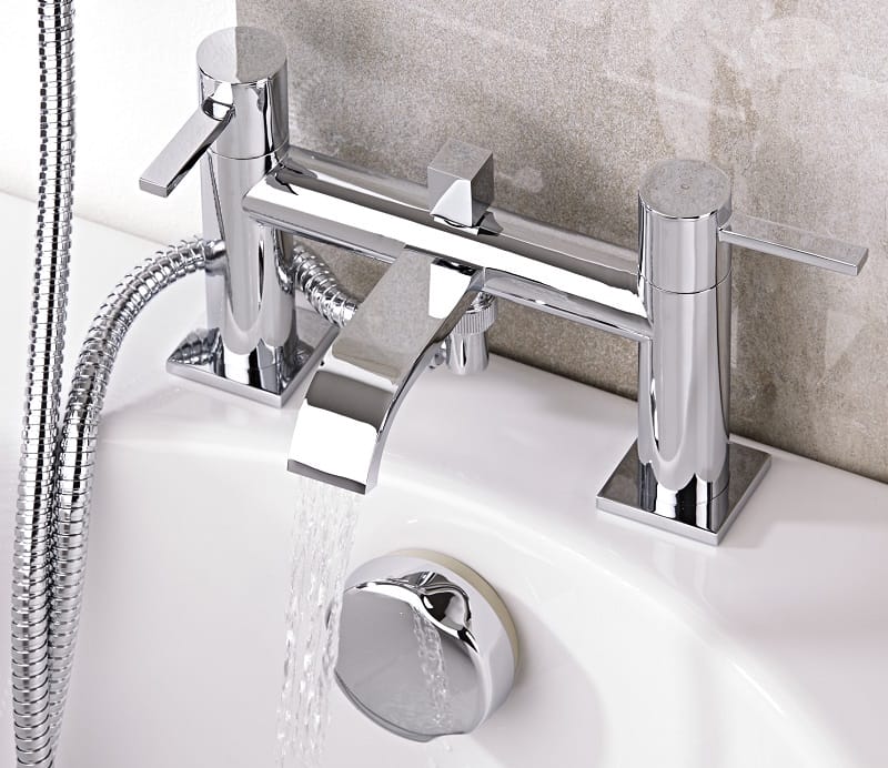 chrome bath tap with water pouring from spout