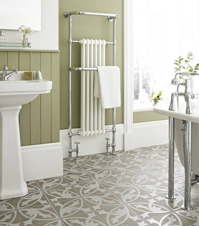 Green bathroom with white furnishings and beige-white patterned tiles with a traditional design