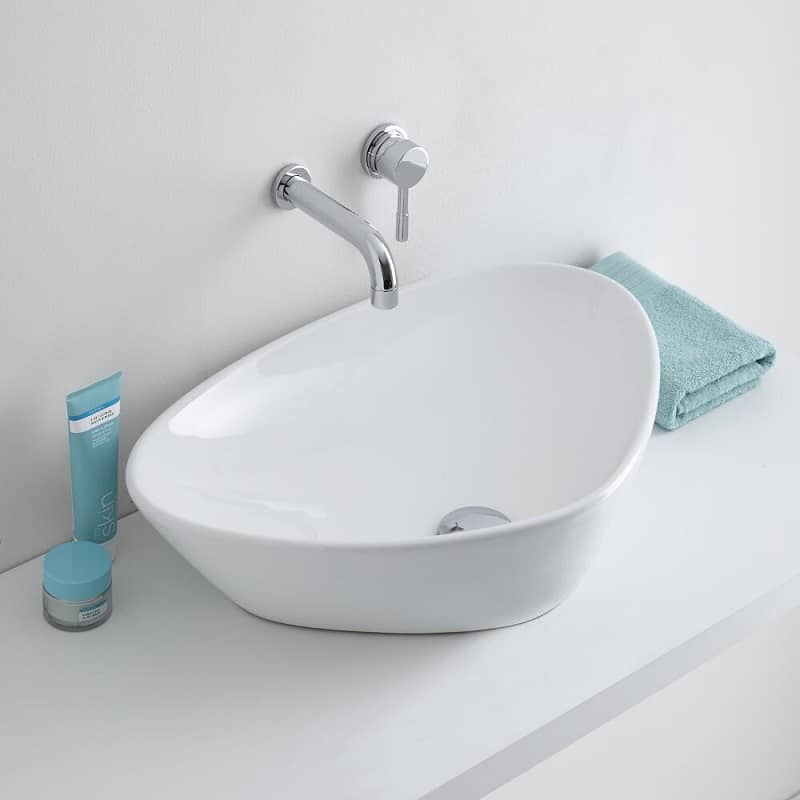 Curved triangular shaped counter top basin with wall mounted tap