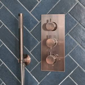 a brushed bronze shower valve and hand shower