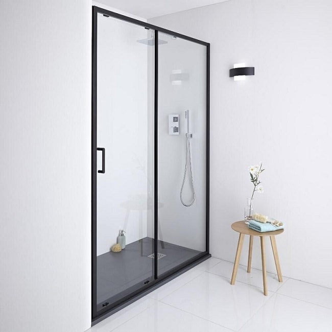 Recess shower with black-framed sliding shower door and shower tray