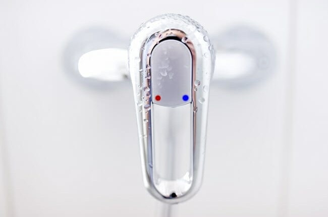 close-up of modern bathroom tap with cold and water symbols on w close-up of modern bathroom tap with cold and water symbols on w