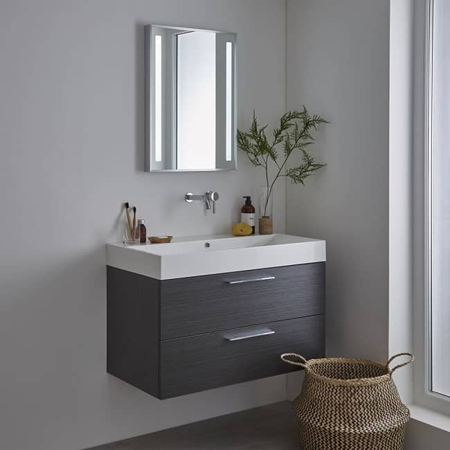 illuminated bathroom mirror with wall hung vanity unit and tap