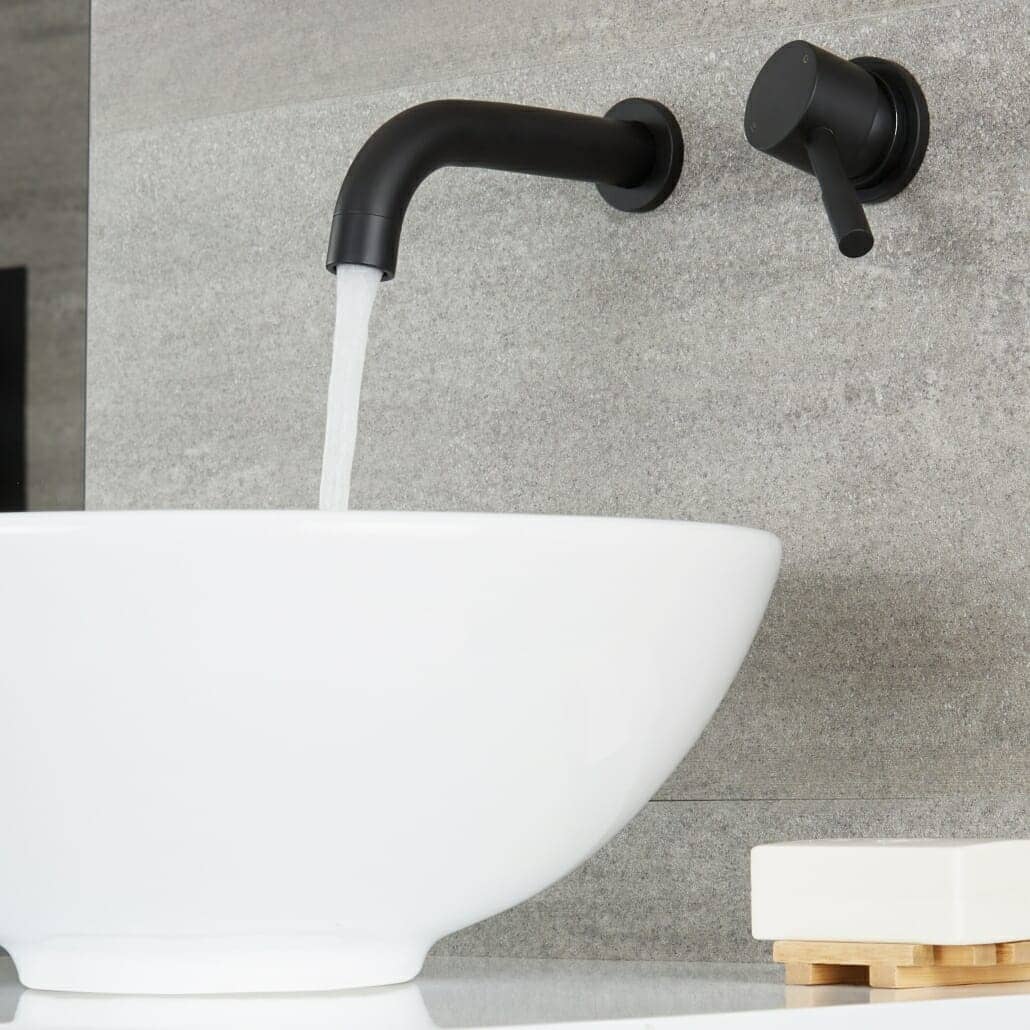 Milano Nero wall mounted basin mixer with water flowing into a basin