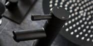 close up of a black basin tap in front of a black shower head