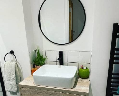 a small bathroom basin and vanity unit with a black tap