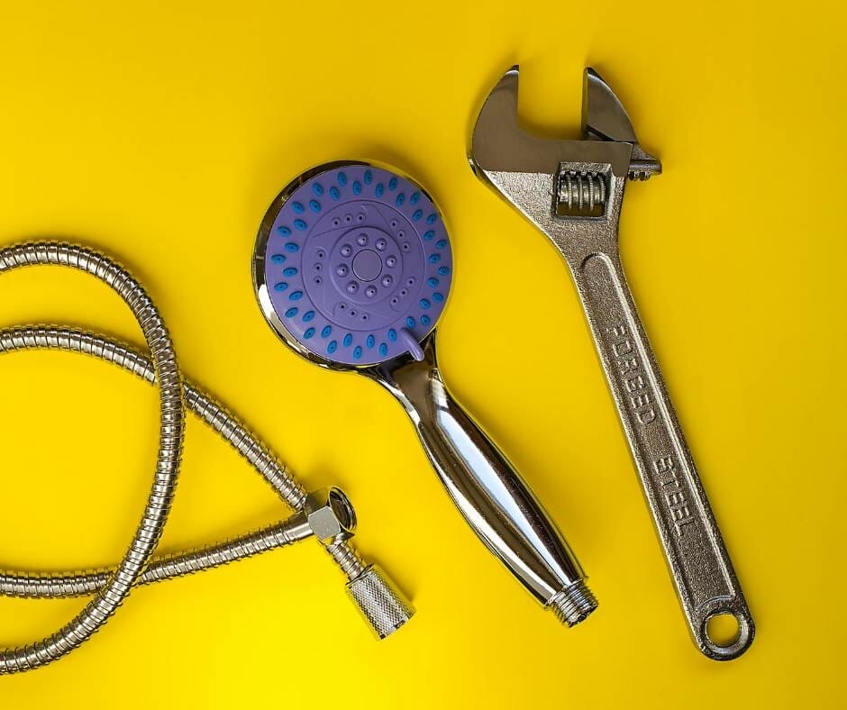 A spanner next to a showerhead