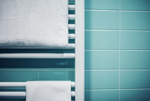 Bathroom Towel Heater a close up of a bathroom towel radiator with towels draped over it