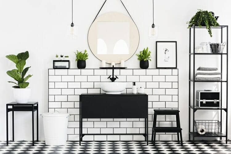 a black and white bathroom filled with plants