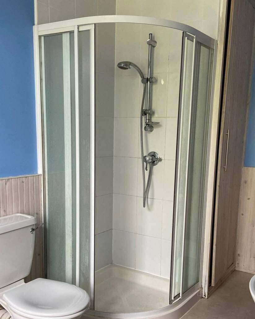 Corner shower enclosure in compact bathroom