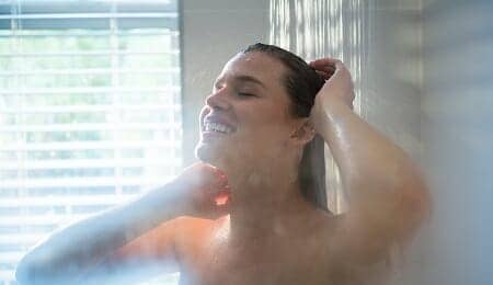 Woman taking a shower in bathroom