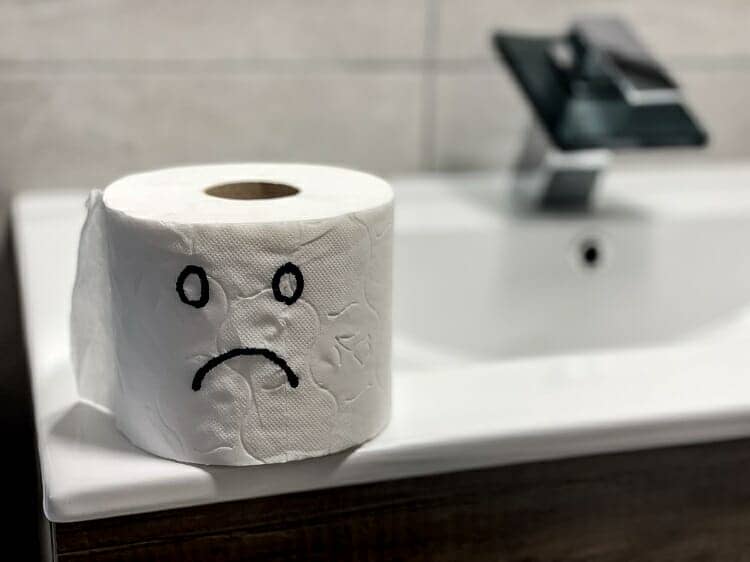 sad face painted on toilet paper roll.