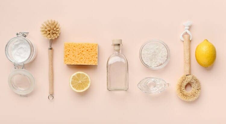 Flat lay composition with eco-friendly natural cleaners. Baking soda, salt, lemon, bamboo brushes on pink background