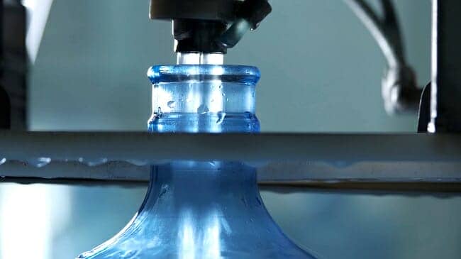 a water bottle being filled with hard water