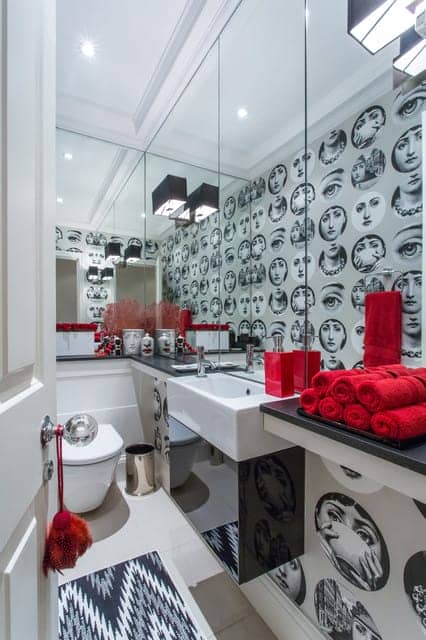 mirrored cloakroom with red towels and black and white print wallpaper